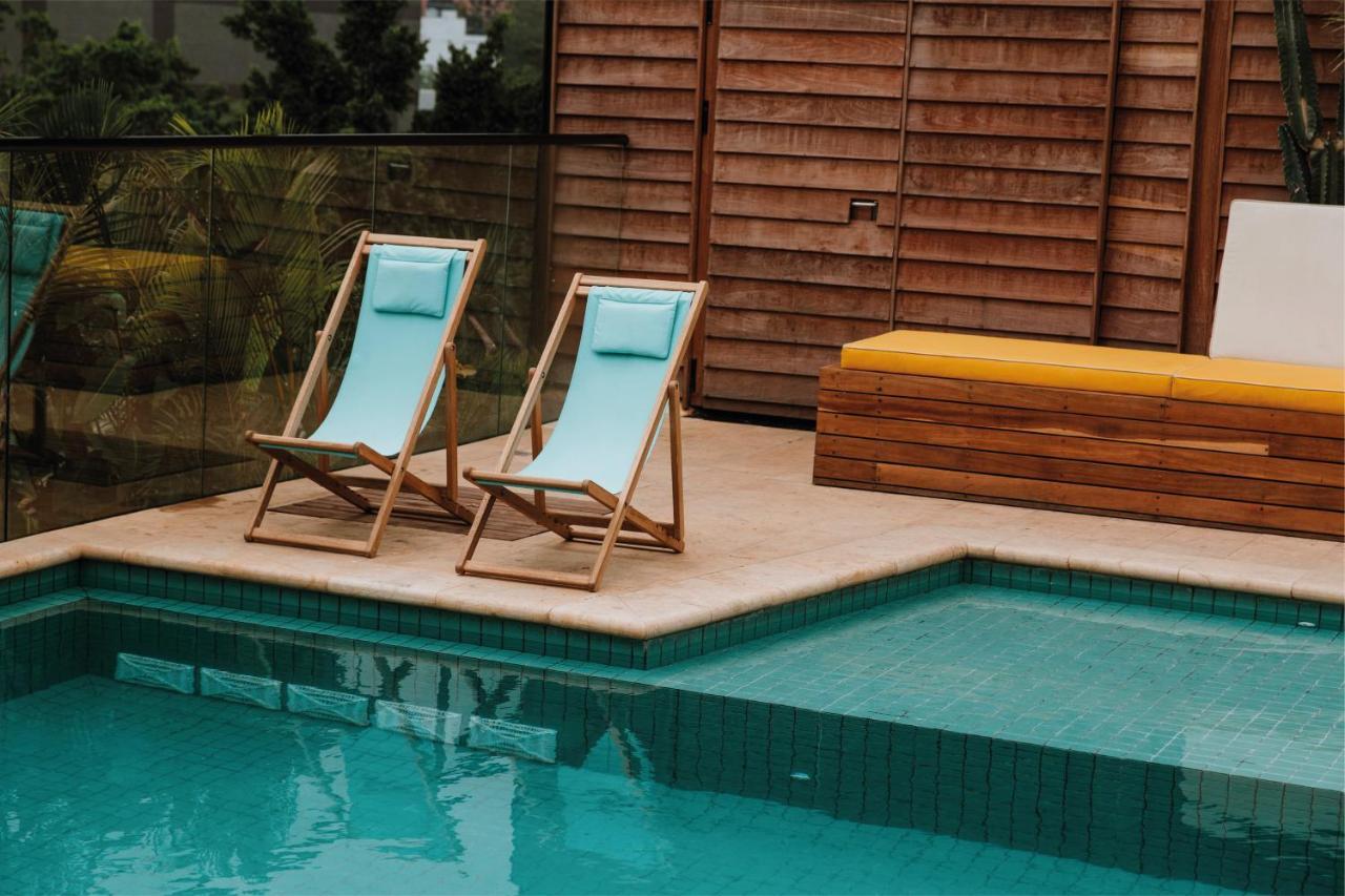 The Click Clack Hotel Medellín Zewnętrze zdjęcie A pair of deck chairs by a pool